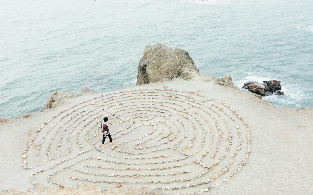 photo of woman walking through a circular sand maze by Ashley Batz for Unsplash