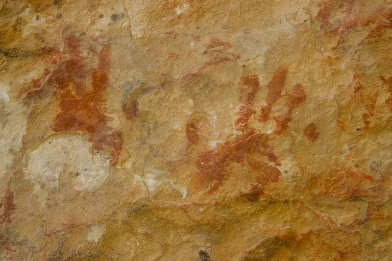 Photo of handprints on rock cave wall by Mike Leyder for Unsplash